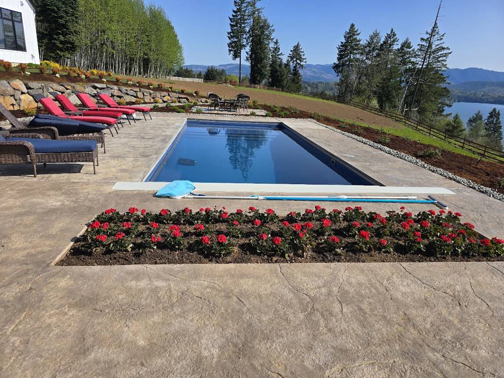 Completed residential pool with stamped concrete patio and rockery retaining wall — Callies Construction, SW Washington